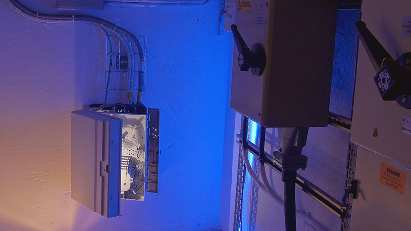 Bilden visar Stokabs installationstekniker i källaren på en fastighet vid en anslutningsnod