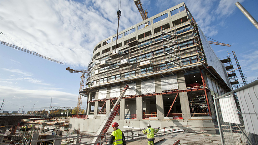 Hus under byggnation med byggkranar