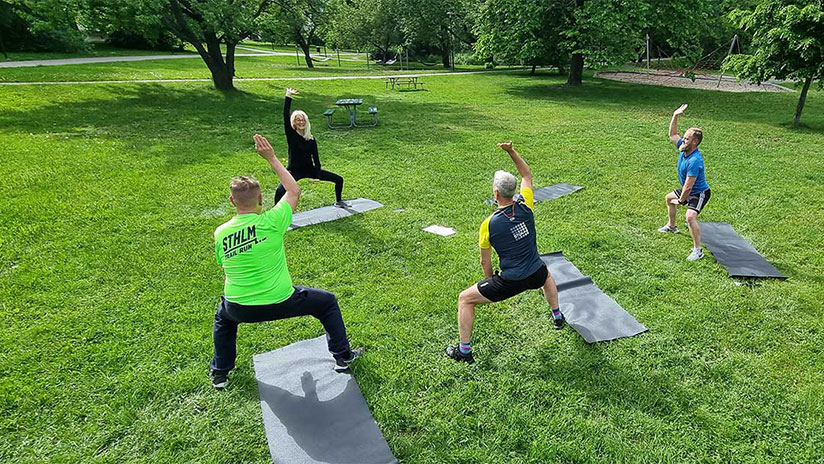 Bilden visar fyra personer från Stokab som gympar tillsammans i en grön park.